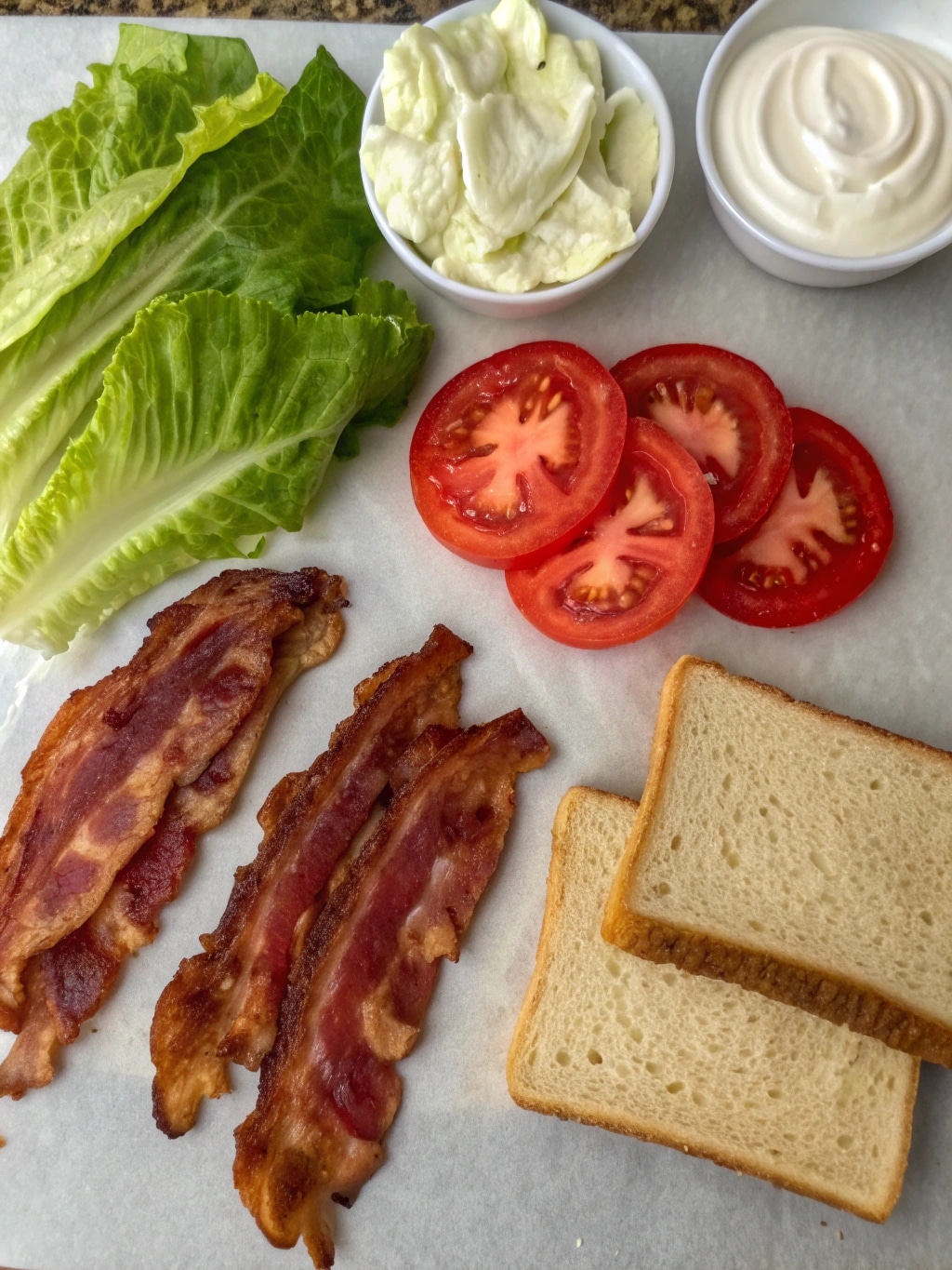 blt sandwich ingredients arranged on a kitchen sur