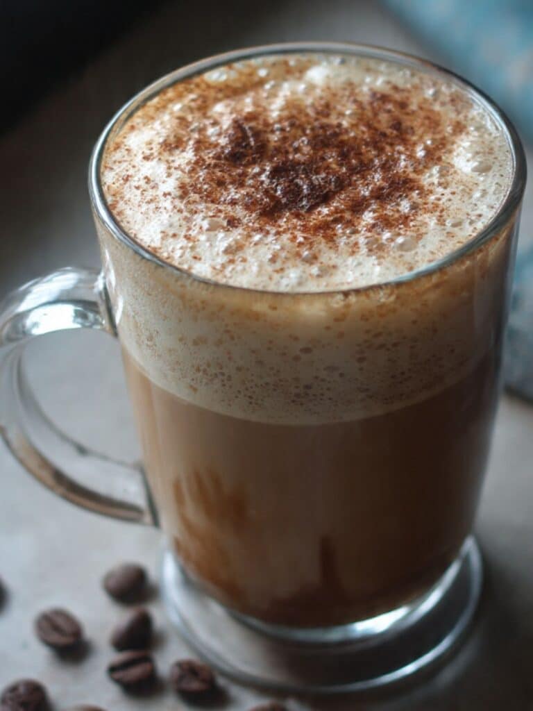 Coffee trick for weight loss showing dark coffee with cinnamon and MCT oil in a white mug.