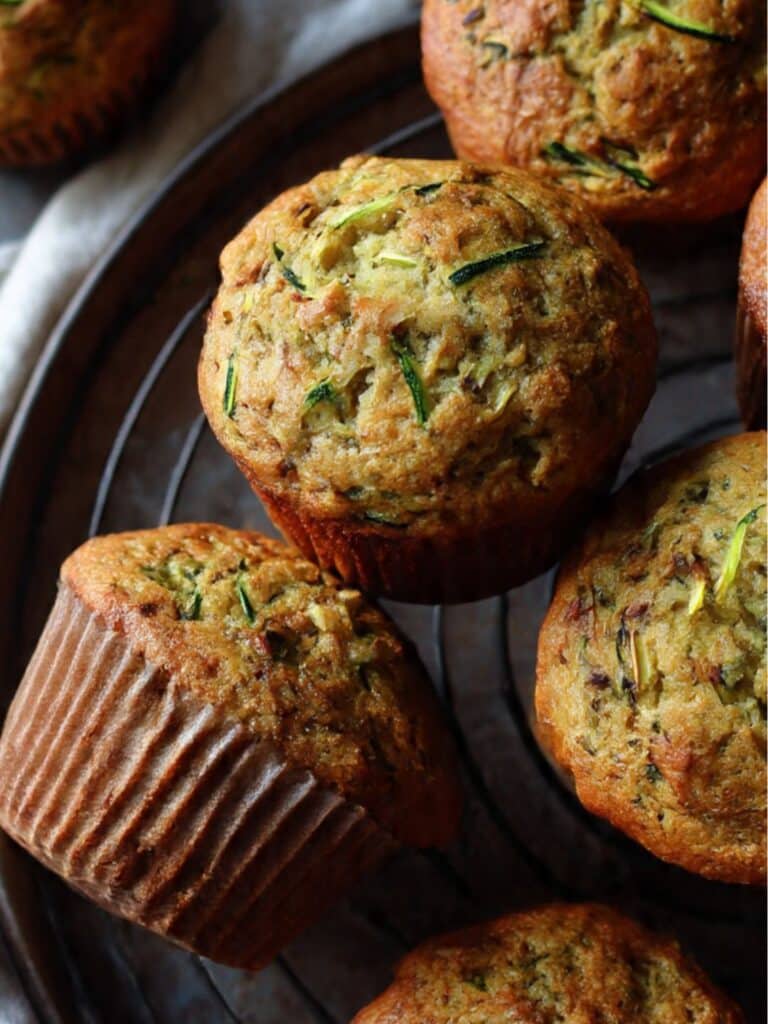 Zucchini muffins recipe freshly baked with golden tops on a wooden rack