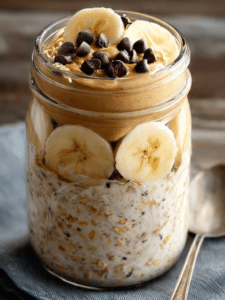 Peanut butter overnight oats in mason jar with banana and chocolate