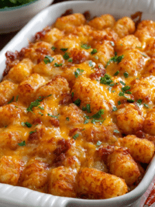 Golden baked tater tot casserole recipe with crispy cheesy topping in glass dish