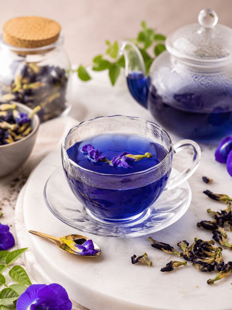 Butterfly Pea Flower Tea in a clear mug with dried flowers and lemon